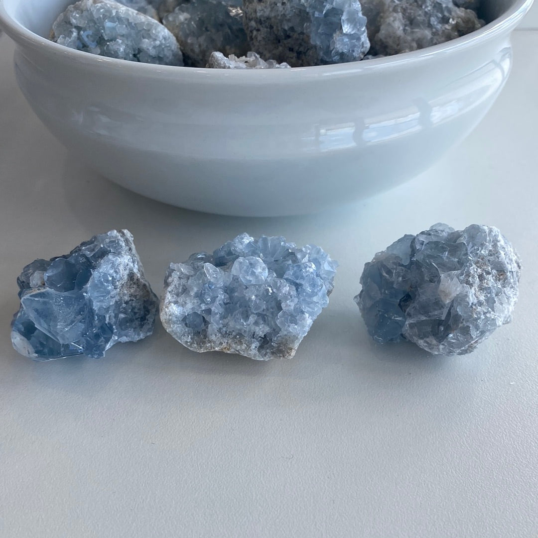 A collection of small Celestite mini geode clusters showcasing their beautiful blue color and unique formations.