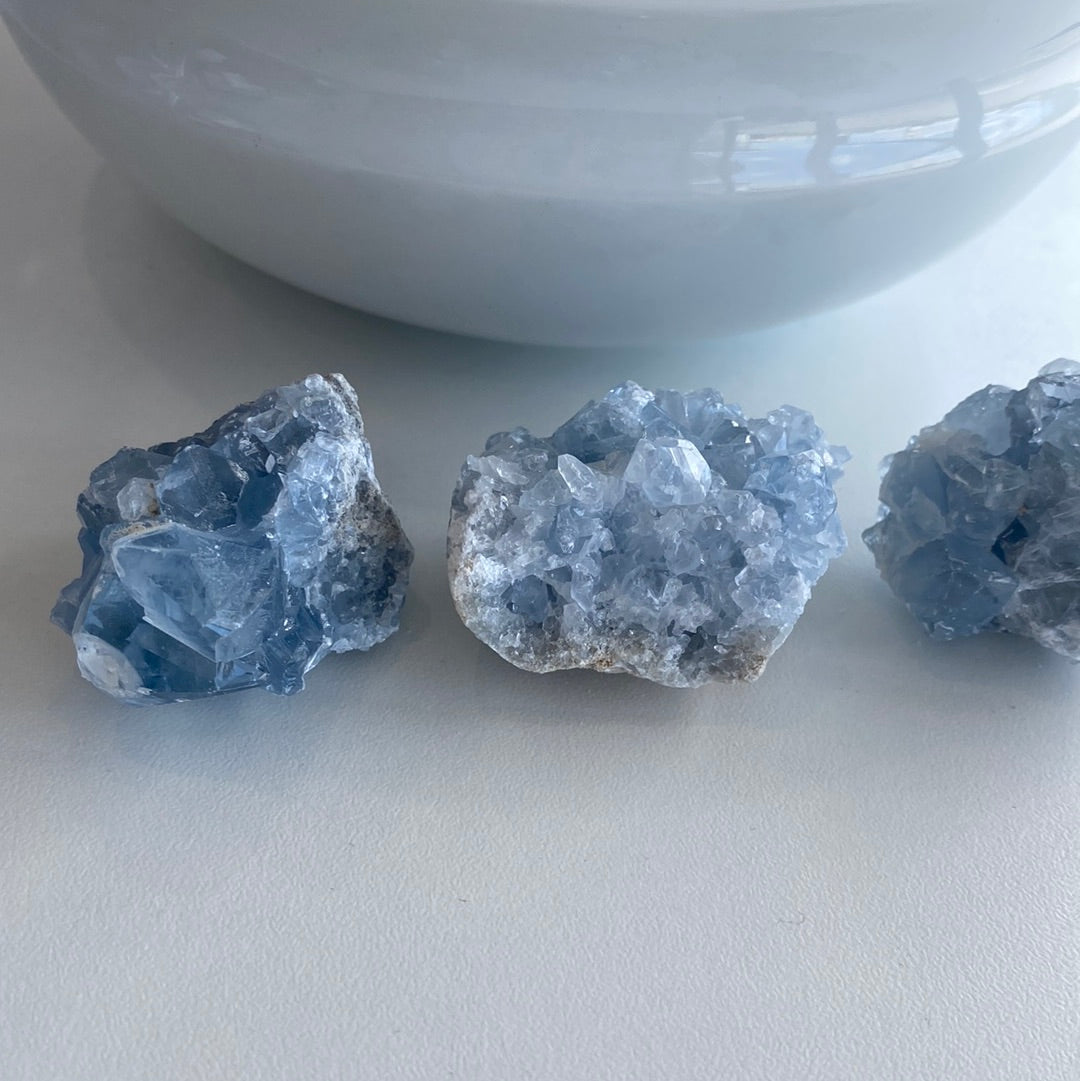 A collection of small Celestite mini geode clusters showcasing their beautiful blue color and unique formations.