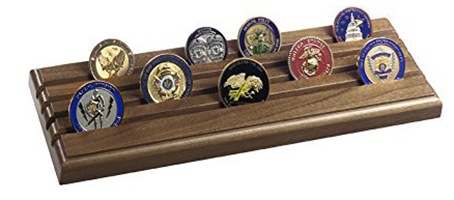 A solid walnut challenge coin rack displaying 28 challenge coins with military .308 brass shell casings.