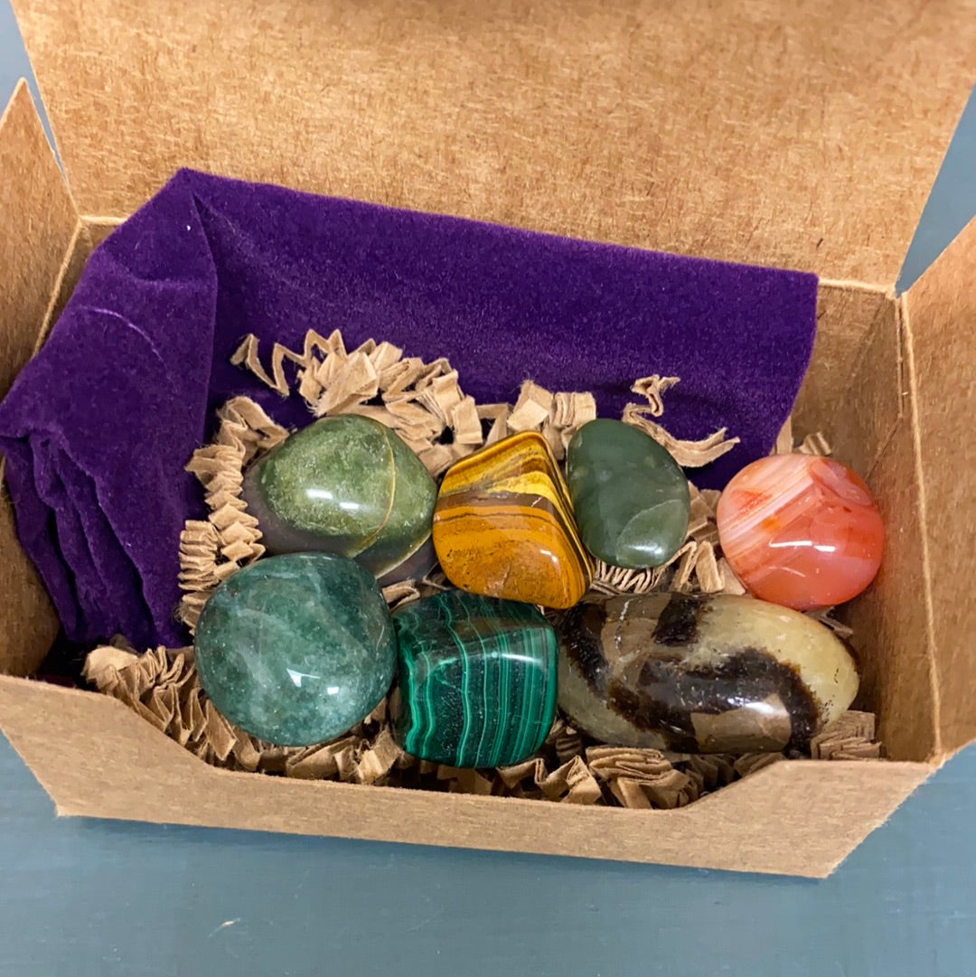 Change Maker Tumbled Stone Bundle featuring seven unique healing stones in a velvet gemstone bag, showcasing their natural beauty and variety.