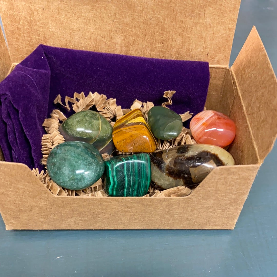 Change Maker Tumbled Stone Bundle featuring seven unique healing stones in a velvet gemstone bag, showcasing their natural beauty and variety.