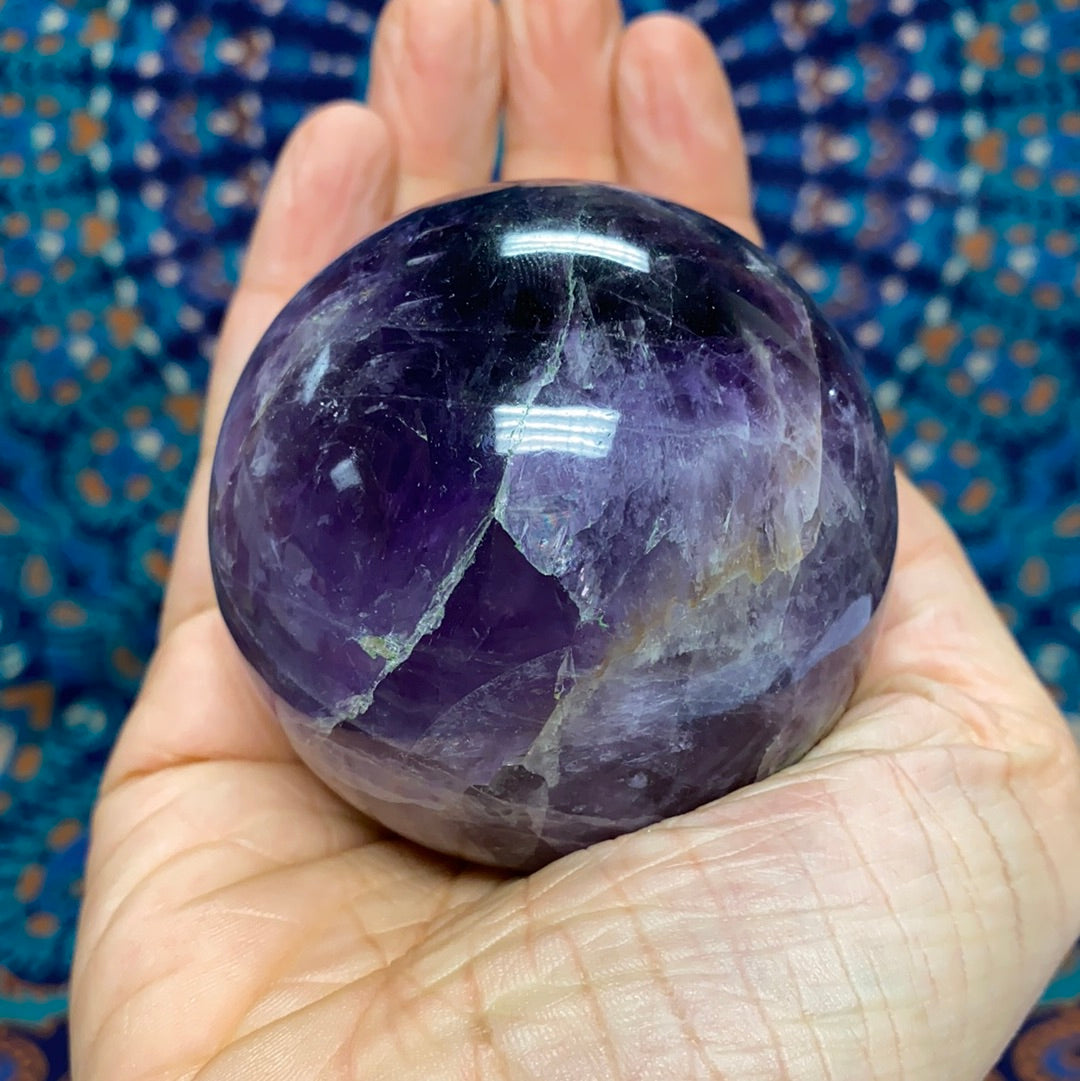 Chevron Amethyst Sphere #5, a 2.5-inch diameter crystal with unique banded patterns, showcasing its purple and white hues.