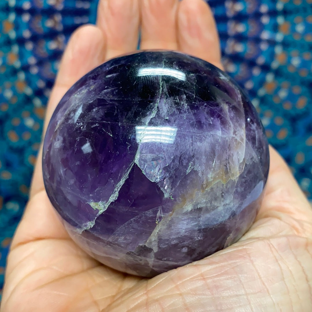 Chevron Amethyst Sphere #5, a 2.5-inch diameter crystal with unique banded patterns, showcasing its purple and white hues.