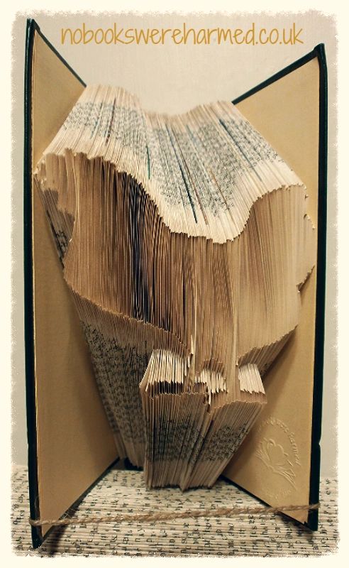 Hand-folded chicken art made from vintage book pages, showcasing intricate design and unique colors.