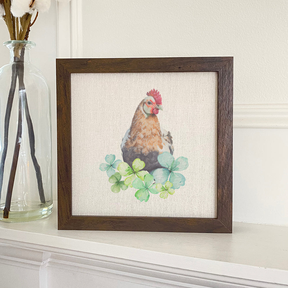 A beautifully framed sign featuring a chicken with clovers, set in a rustic wood frame, available in walnut or white-washed finish.