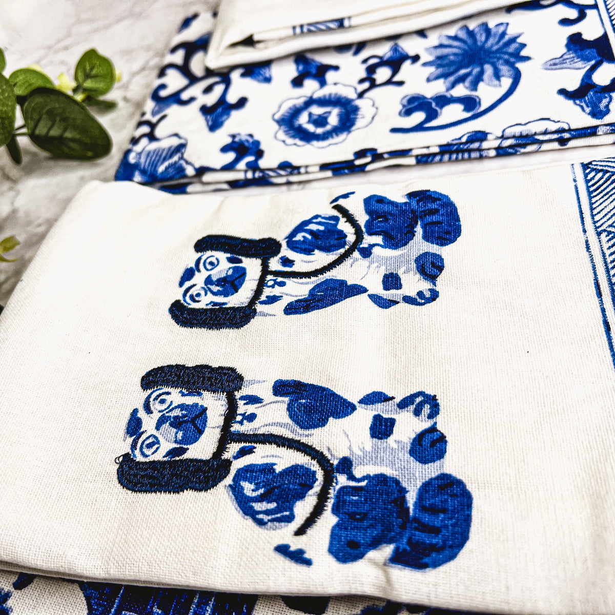 Beautiful Chinoiserie Tea Towels with blue and white embroidery and decorative tassels, showcasing their oversized design.