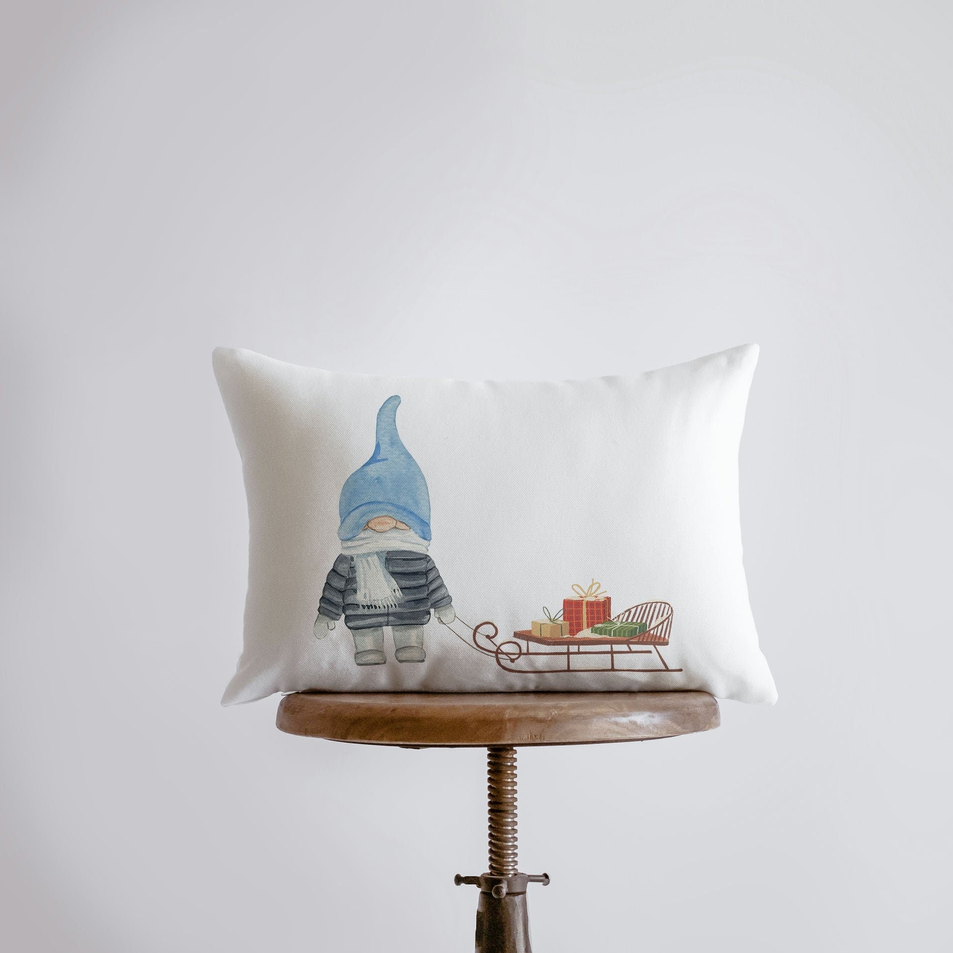 Hand-made Christmas Gnome Blue throw pillow featuring a watercolor gnome holding a sleigh, perfect for holiday decor.