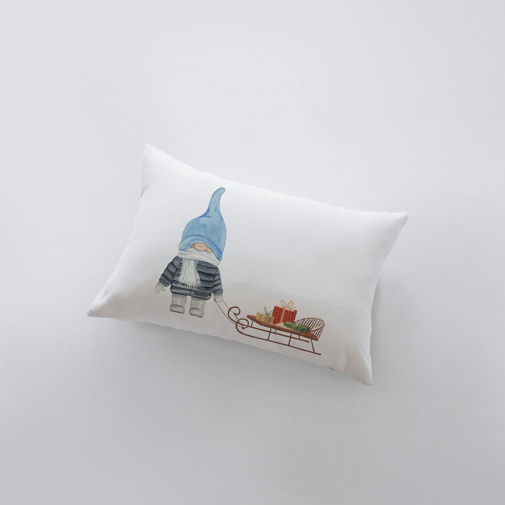 Hand-made Christmas Gnome Blue throw pillow featuring a watercolor gnome holding a sleigh, perfect for holiday decor.