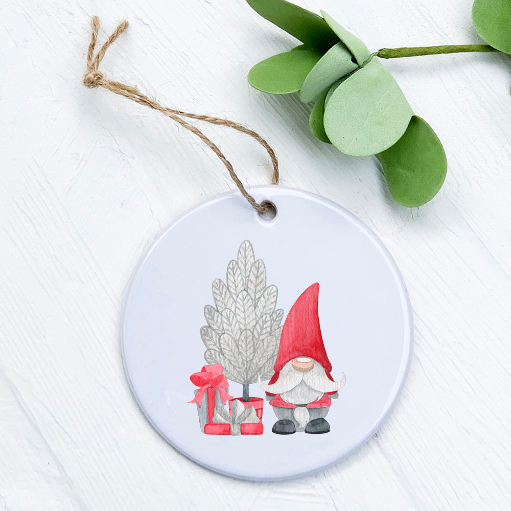 A charming Christmas Gnome ornament with a tree, made of high-quality porcelain, featuring vibrant colors and a glossy finish.