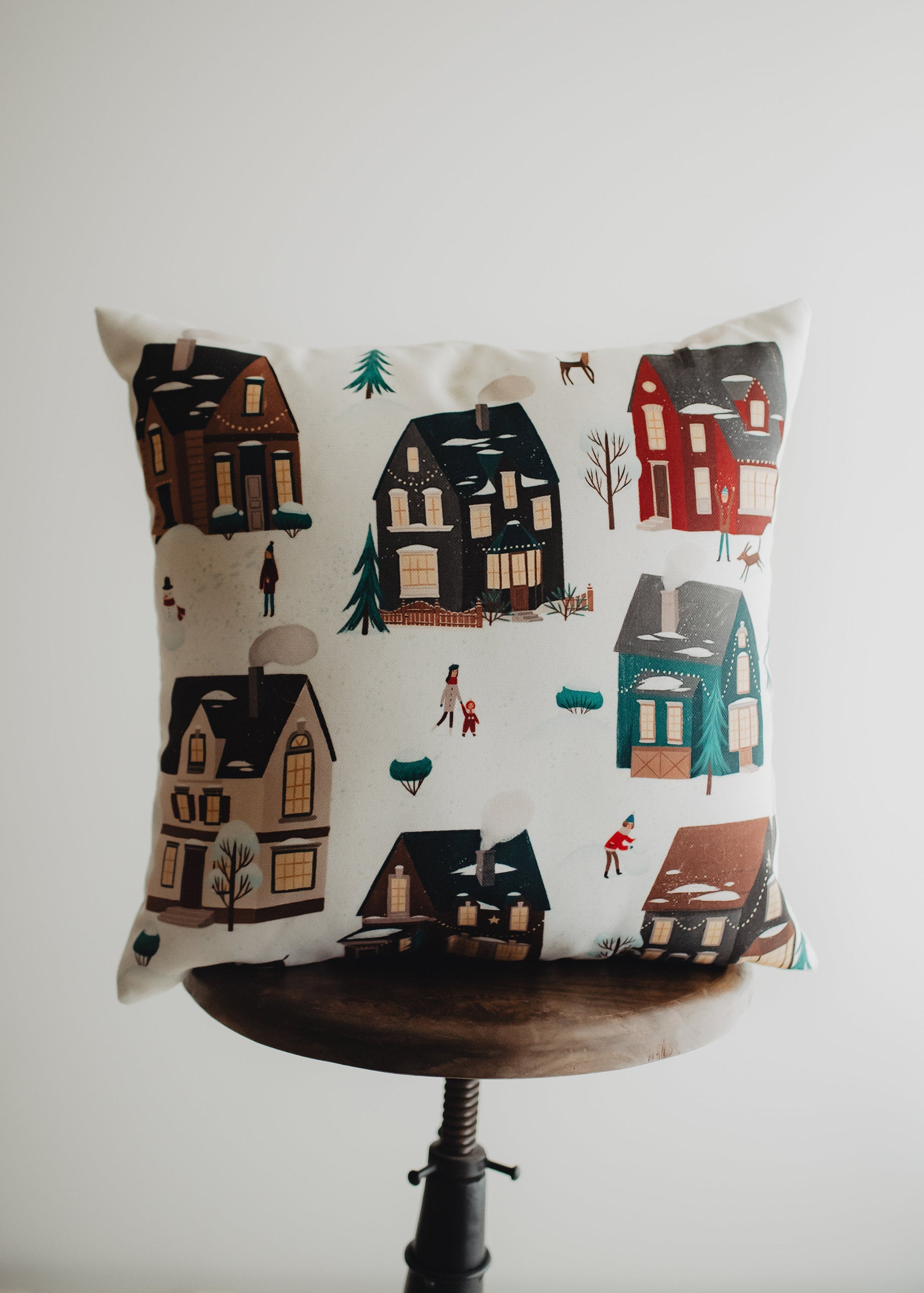 Christmas Village Houses Throw Pillow Cover featuring a snowy village scene with houses and neighbors, made in America.