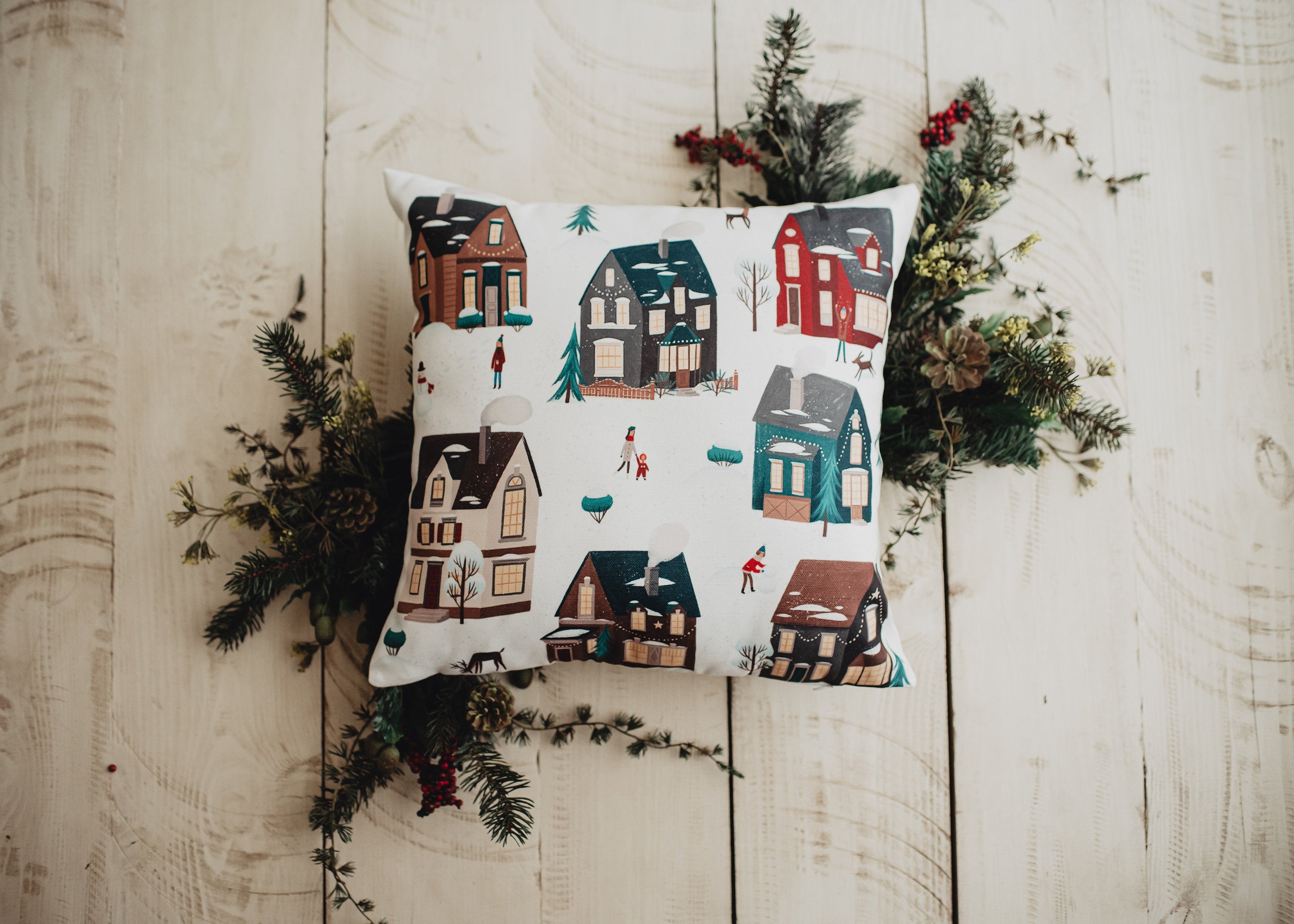 Christmas Village Houses Throw Pillow Cover featuring a snowy village scene with houses and neighbors, made in America.