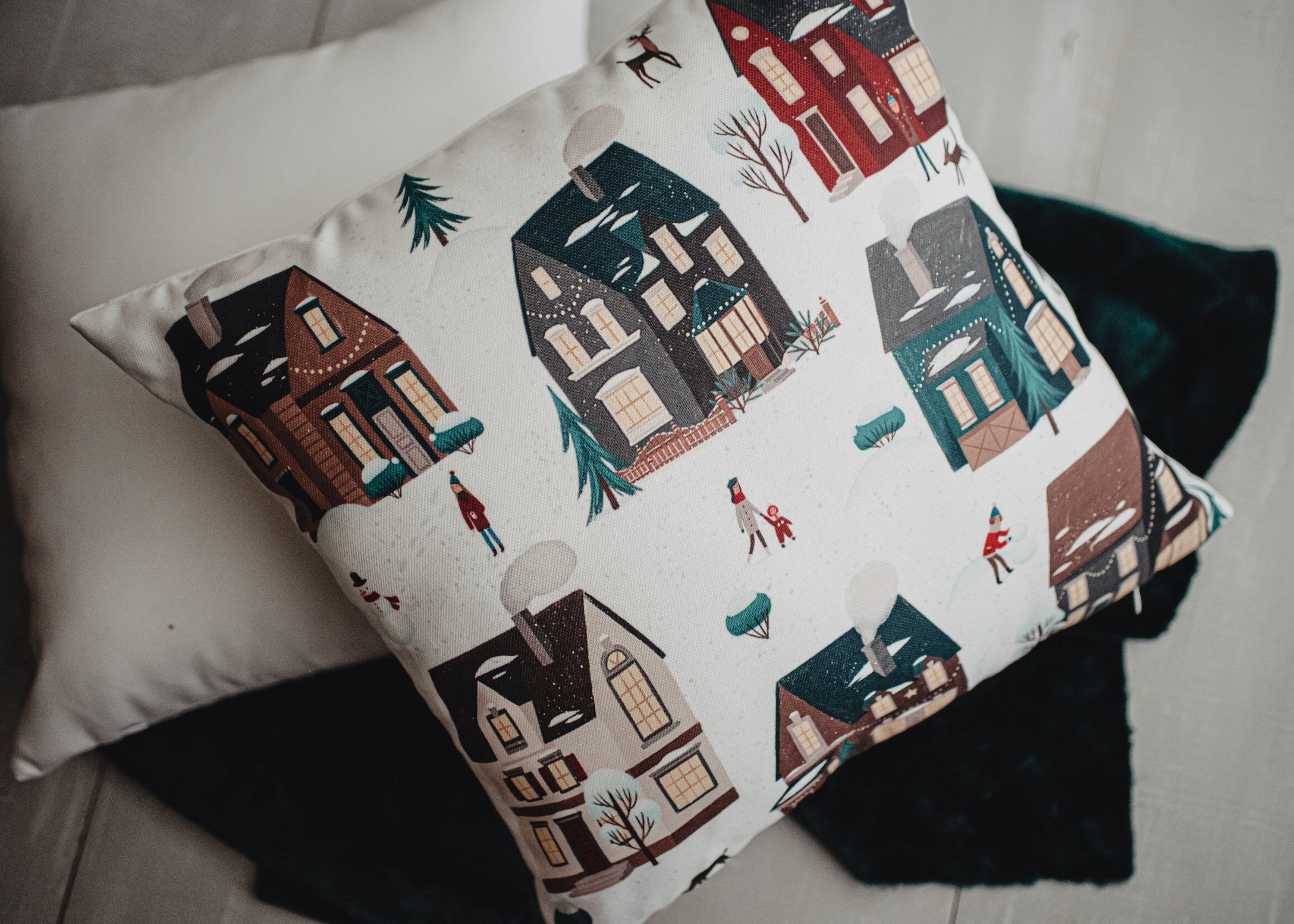 Christmas Village Houses Throw Pillow Cover featuring a snowy village scene with houses and neighbors, made in America.