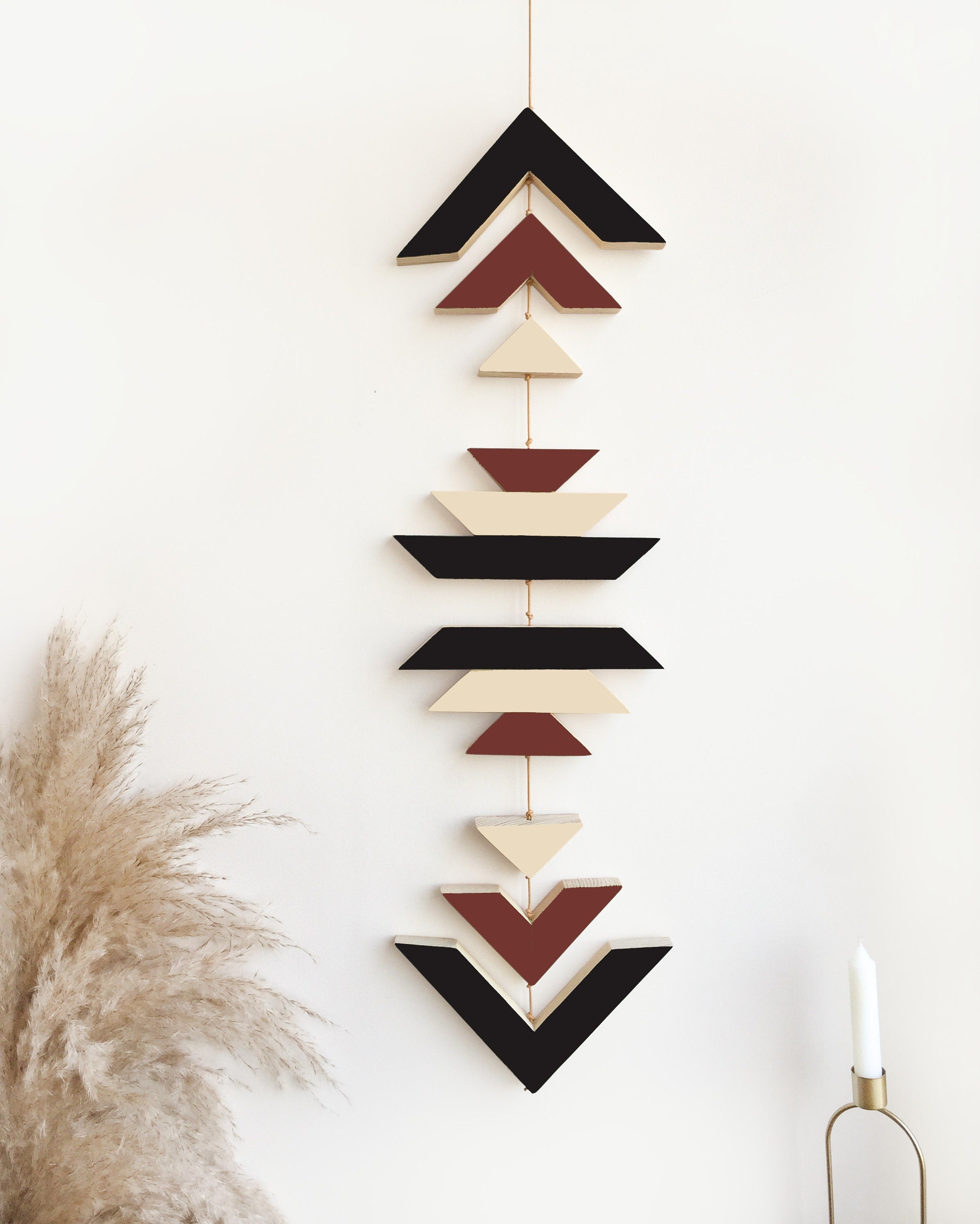 A beautiful cinnamon wood wall hanging featuring geometric designs, connected with cream cotton cord, perfect for boho decor.