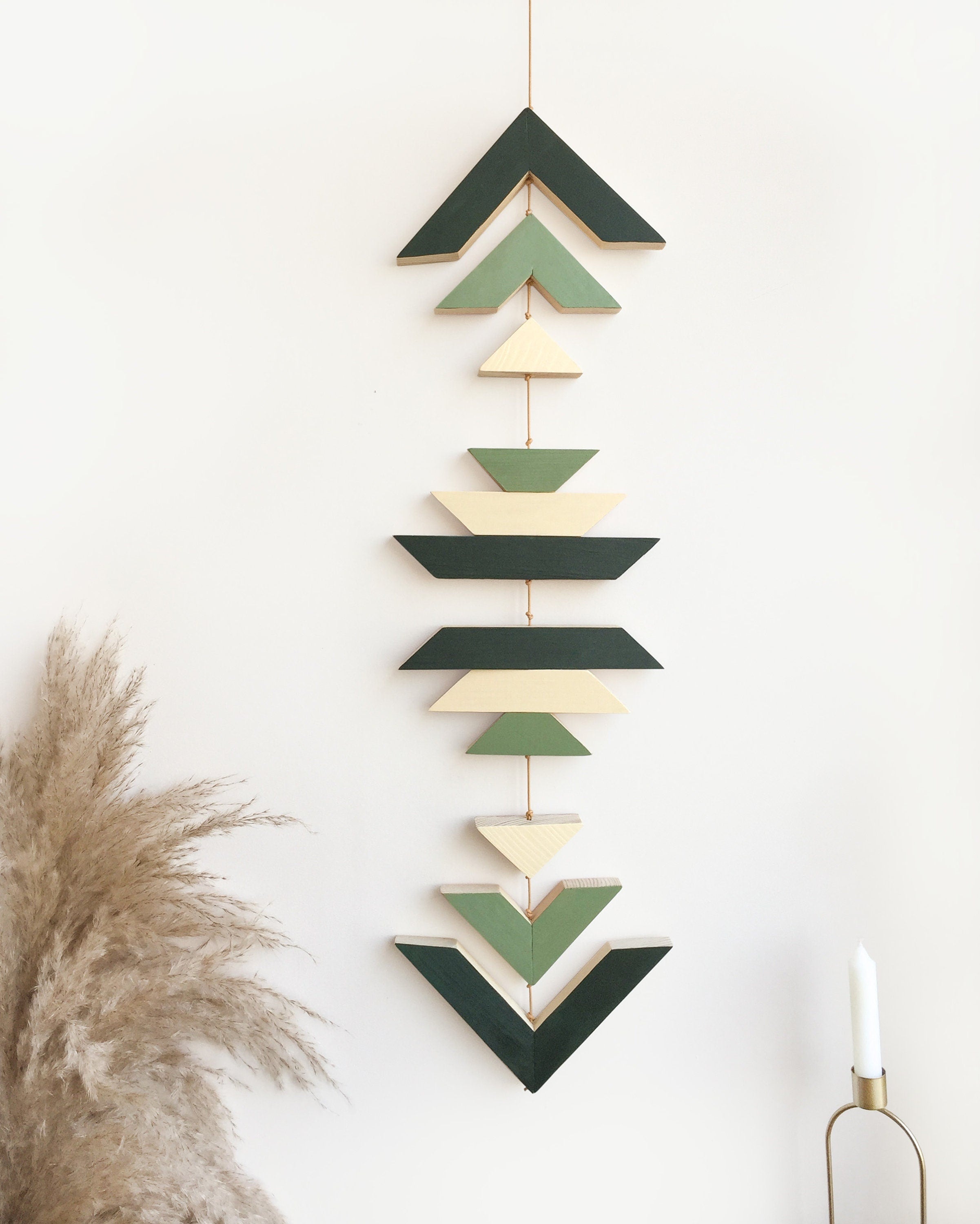 A beautiful cinnamon wood wall hanging featuring geometric designs, connected with cream cotton cord, perfect for boho decor.