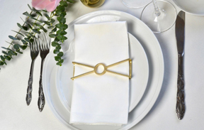 Circle X Wrap Matte Gold napkin rings elegantly displayed on a dining table, showcasing their unique design and luxurious finish.