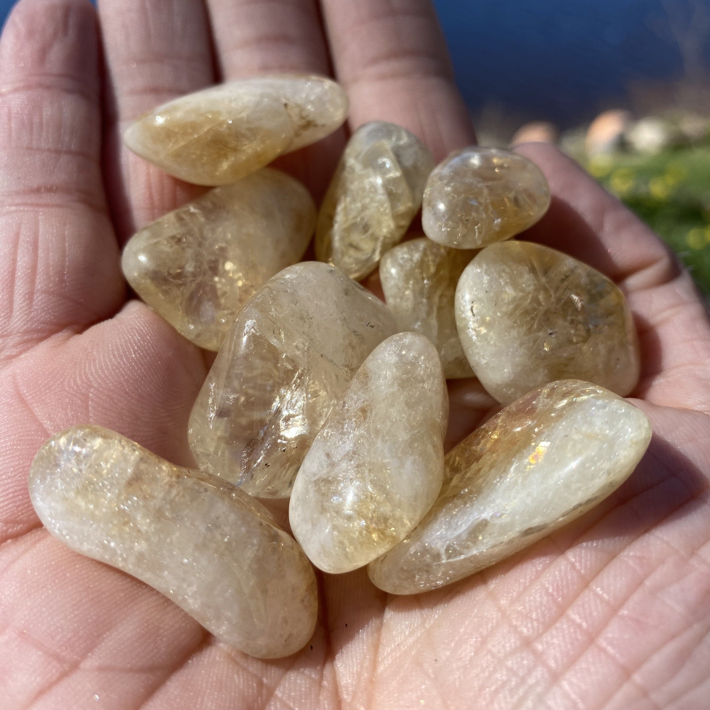 A collection of Citrine Tumbled Crystal Stones showcasing vibrant yellow to golden brown hues, perfect for energy work and decoration.