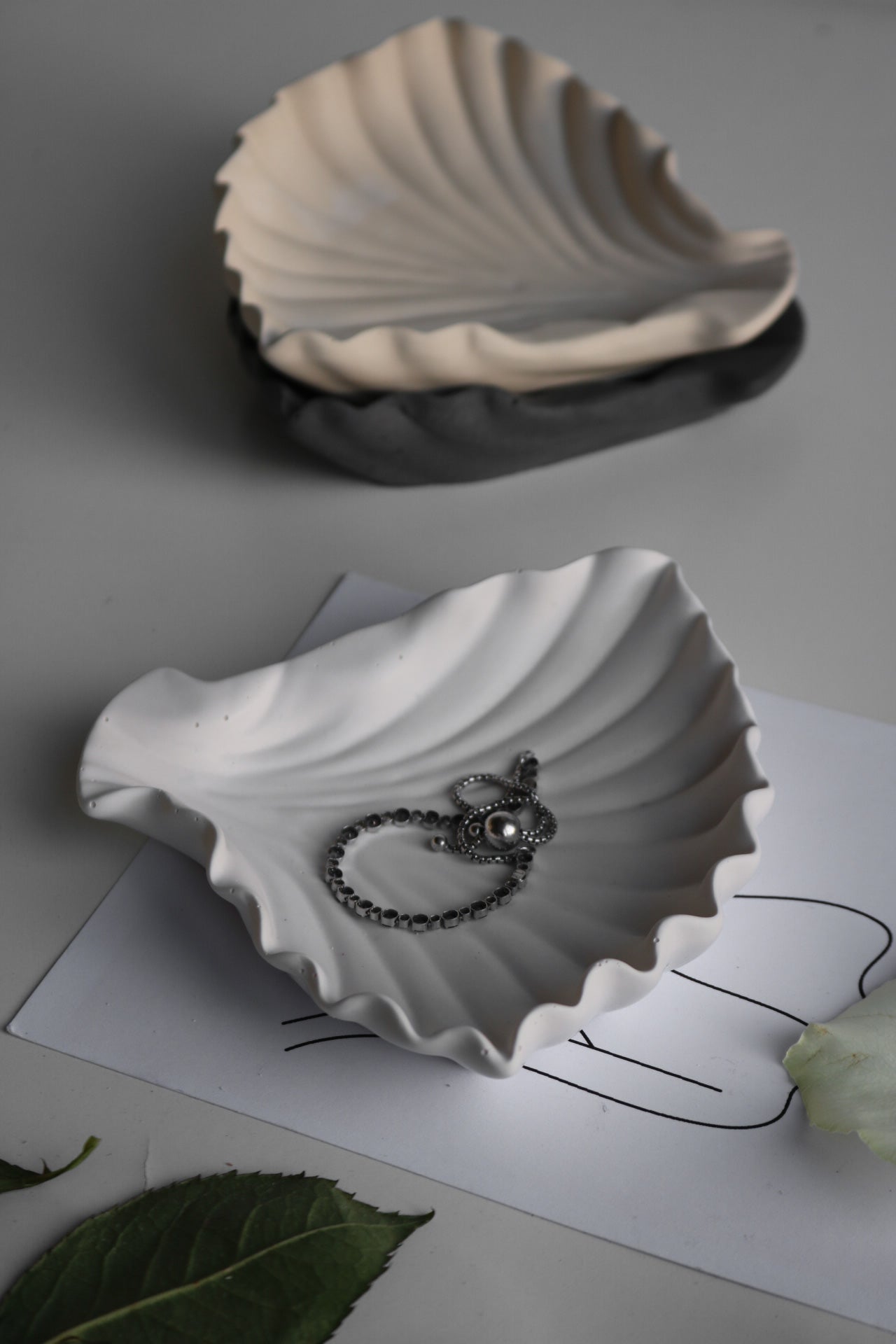 A hand-made clam shell jewellery dish in a soft color, showcasing its unique texture and elegant design, perfect for storing trinkets.