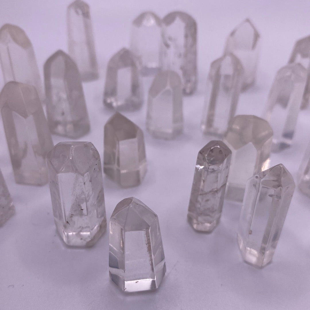 A polished 1/2 inch clear quartz point, showcasing its translucent beauty and six-sided crystal structure.