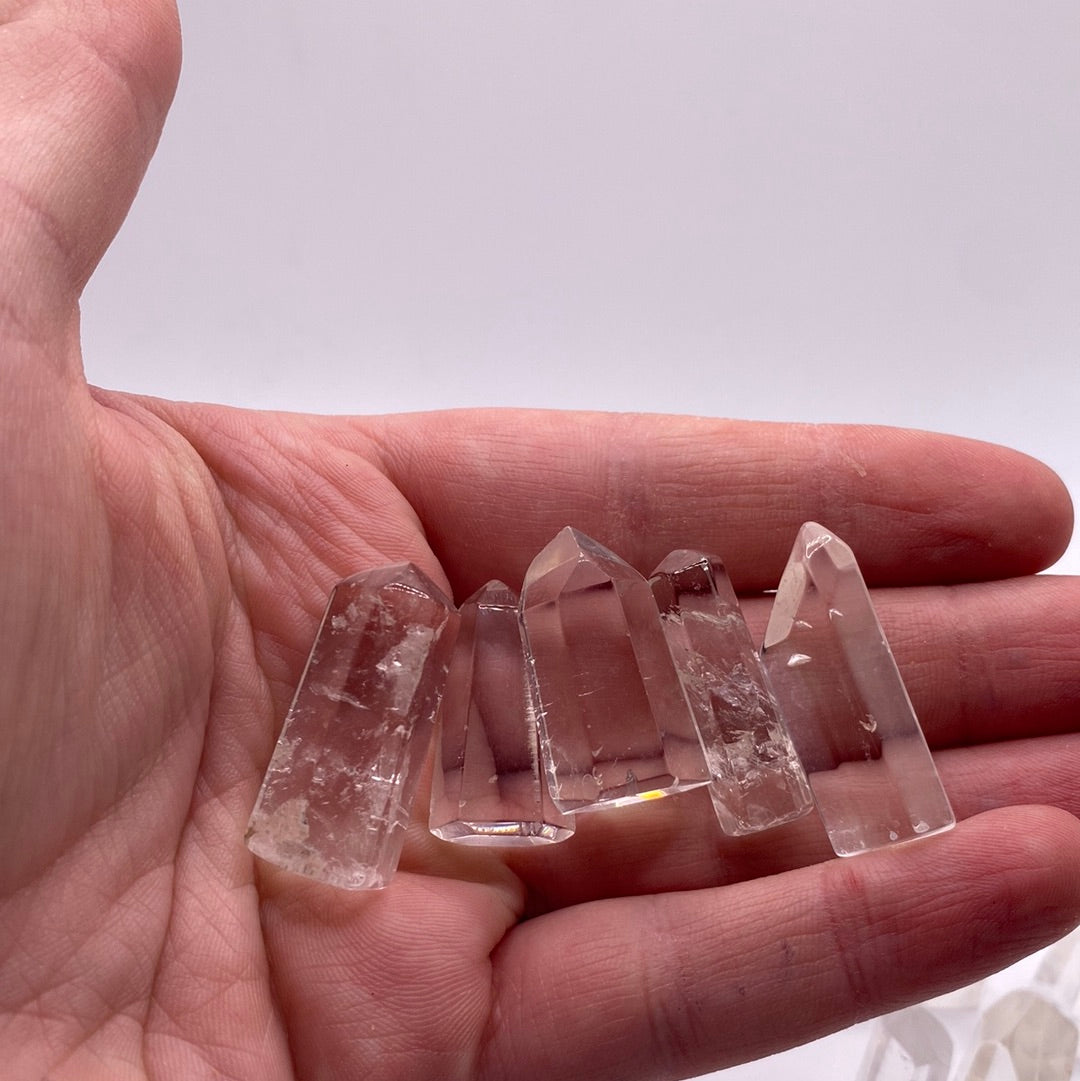 A polished 1/2 inch clear quartz point, showcasing its translucent beauty and six-sided crystal structure.