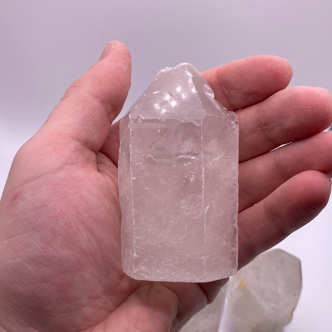 A clear quartz point with a cut base, showcasing its natural clarity and beauty, ideal for meditation and energy work.