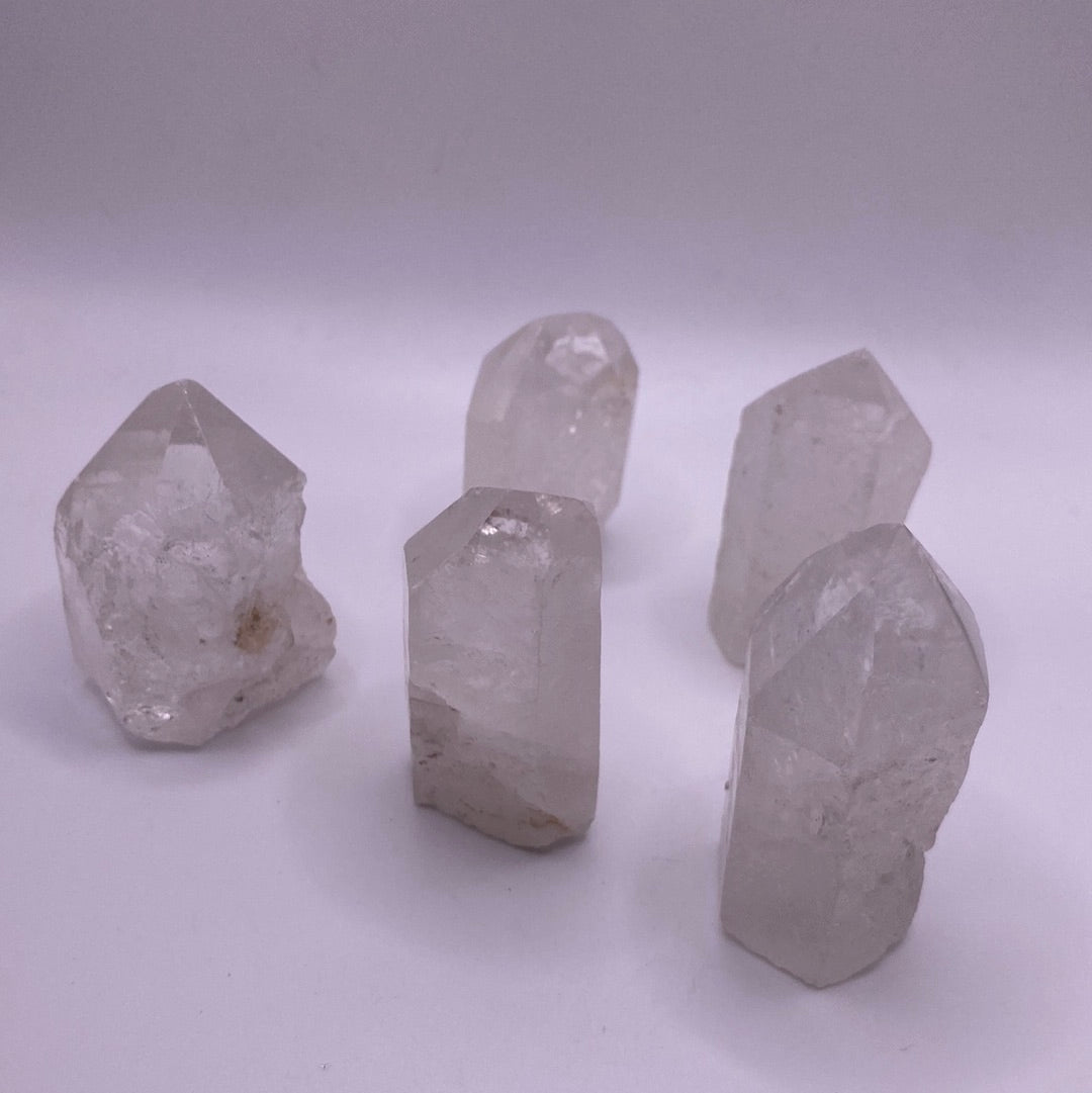 A clear quartz point with a cut base, showcasing its natural clarity and beauty, ideal for meditation and energy work.