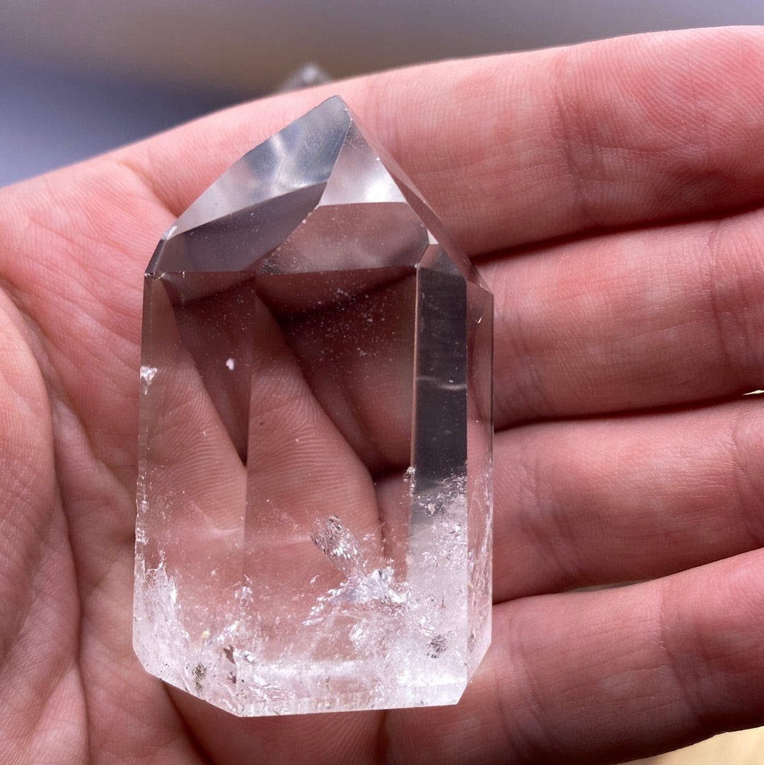 A beautifully polished Clear Quartz Tower from Brazil, showcasing its smooth surface and reflective facets, radiating clarity and energy.