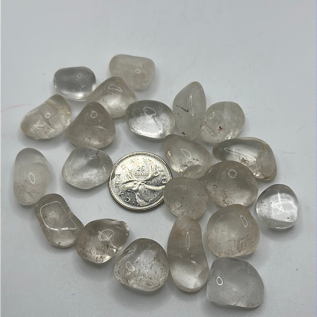 A collection of Clear Quartz tumbled crystal stones, showcasing their unique shapes and sizes, perfect for healing and meditation.