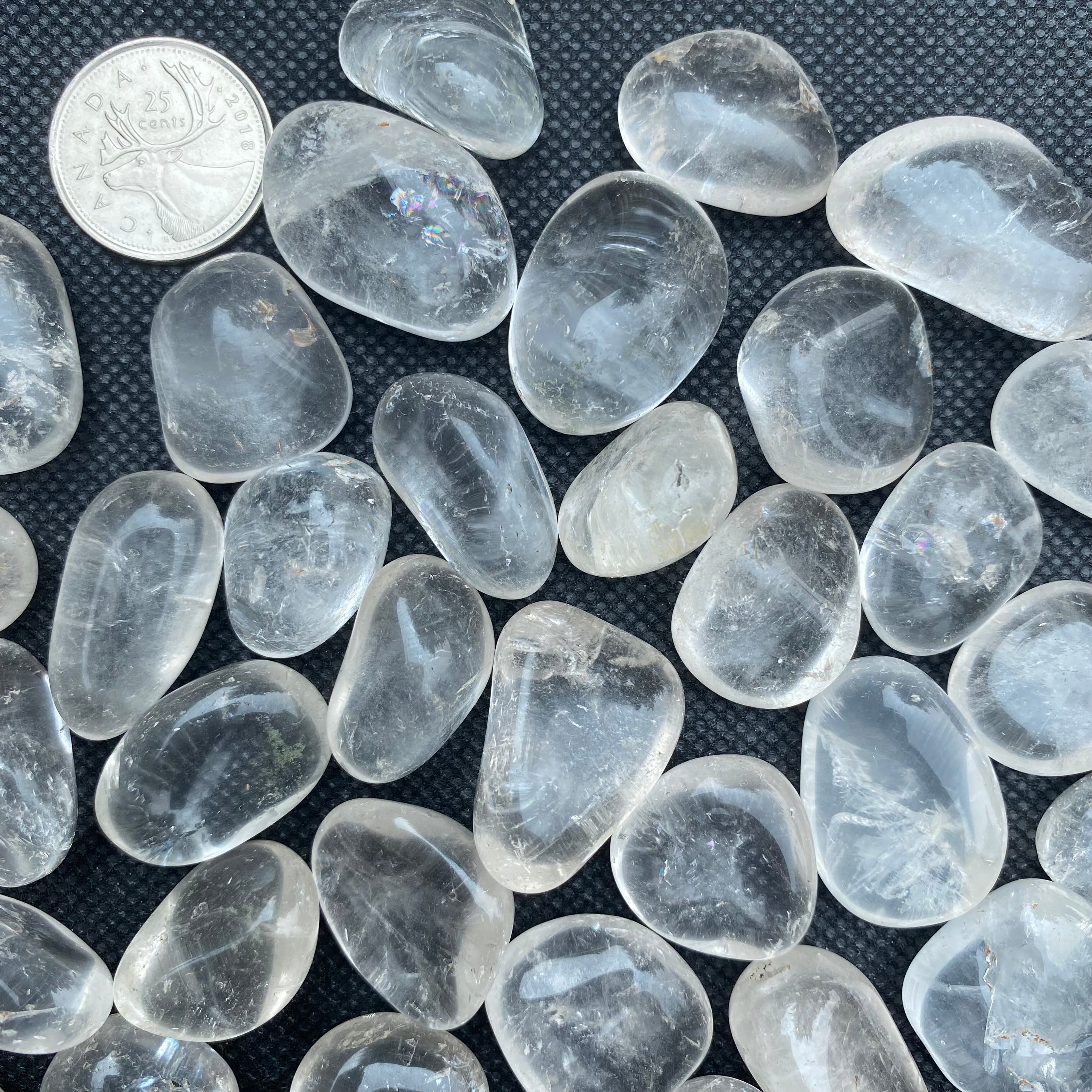 A collection of Clear Quartz Tumbled Crystal Stones, showcasing their unique shapes and sizes, perfect for healing and meditation.