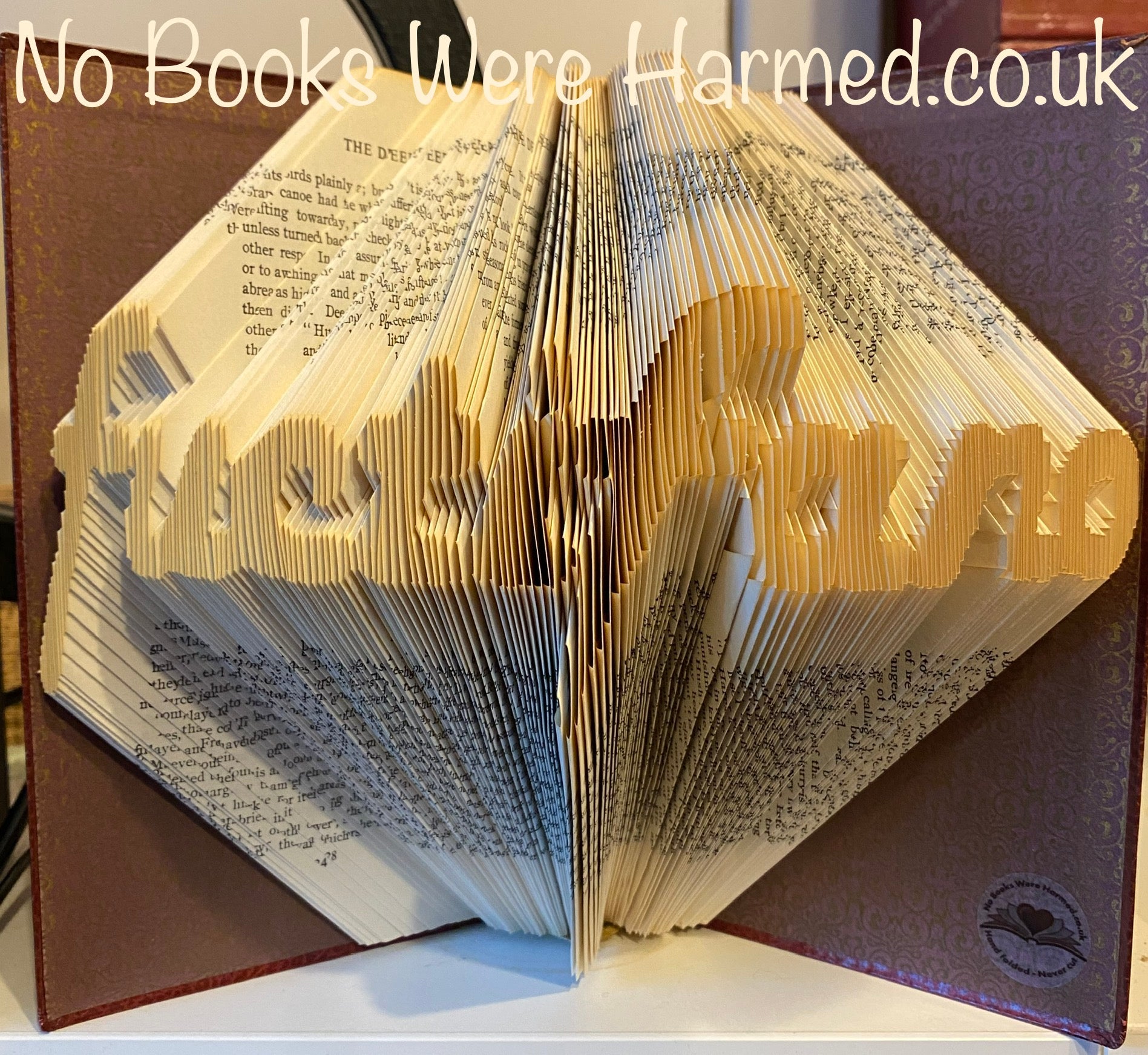 Hand-folded book art made from reclaimed vintage books, showcasing unique designs and intricate folds.