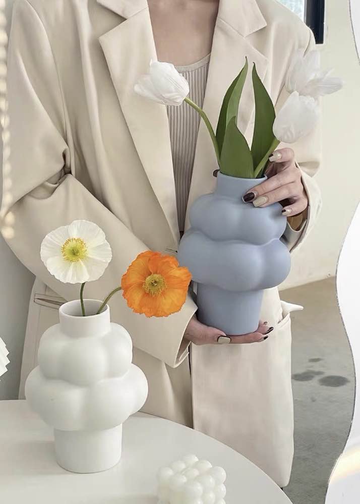 A whimsical ceramic flower vase shaped like a cloud, showcasing its unique design and smooth finish.