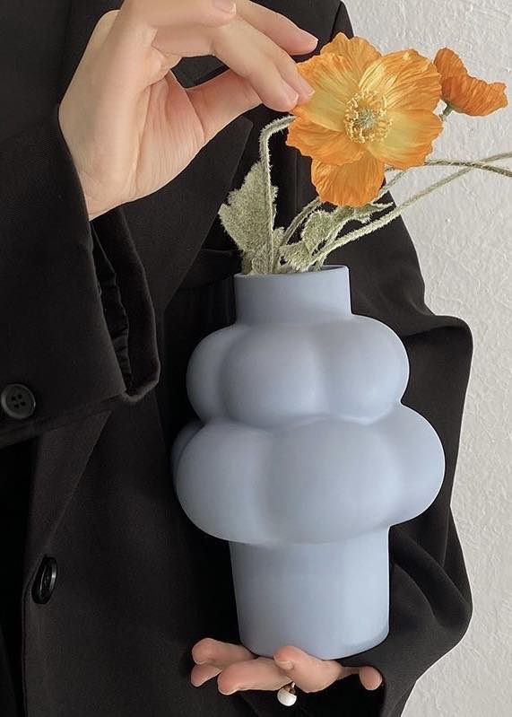 A whimsical ceramic flower vase shaped like a cloud, showcasing its unique design and smooth finish.