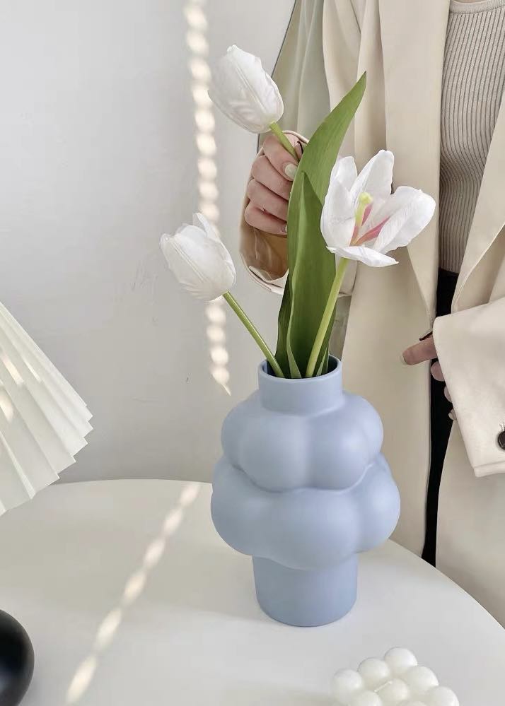 A whimsical ceramic flower vase shaped like a cloud, showcasing its unique design and smooth finish.