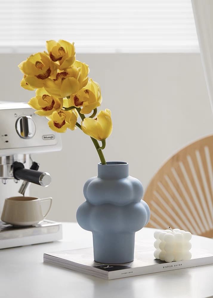 A whimsical ceramic flower vase shaped like a cloud, showcasing its unique design and smooth finish.