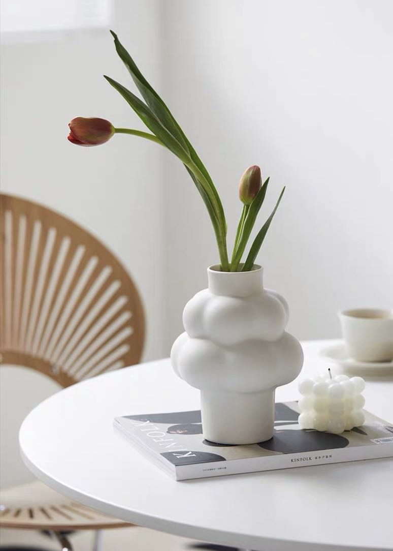 A whimsical ceramic flower vase shaped like a cloud, showcasing its unique design and smooth finish.