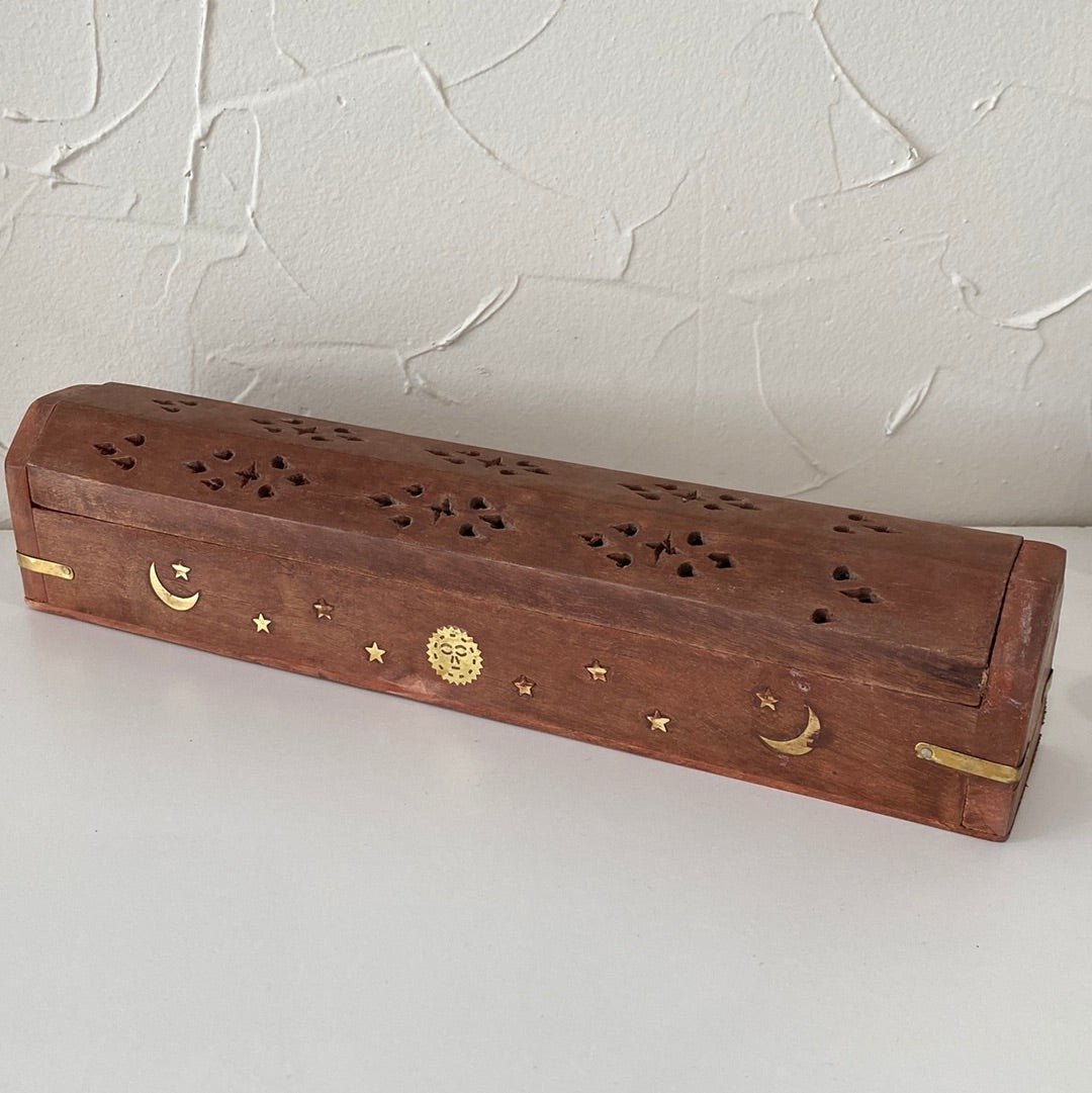 A wooden coffin-shaped incense holder with a hole for incense sticks and a compartment for ash collection.