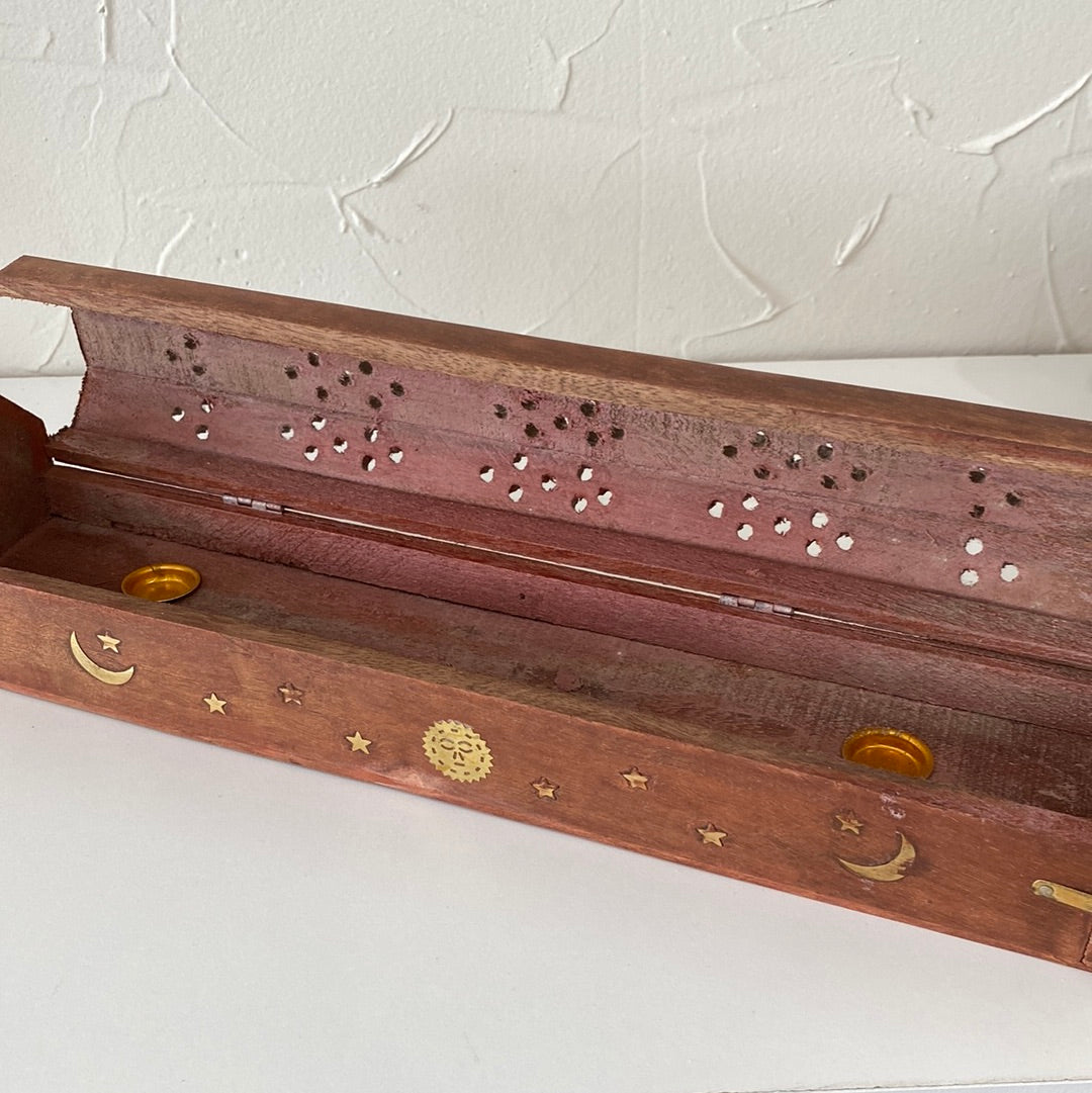 A wooden coffin-shaped incense holder with a hole for incense sticks and a compartment for ash collection.