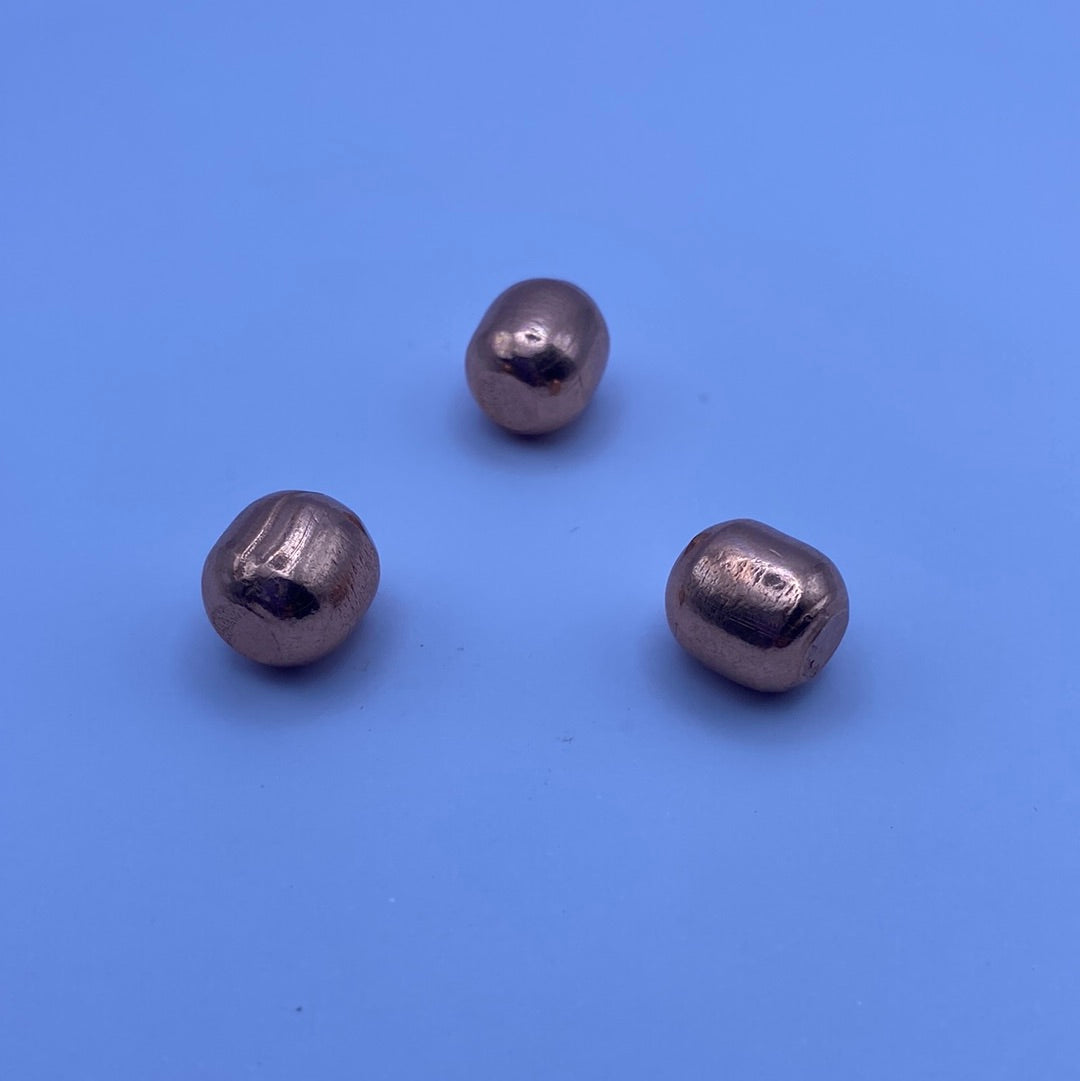 A collection of shiny, polished mini copper balls, showcasing their smooth surface and rich color, perfect for spiritual practices.