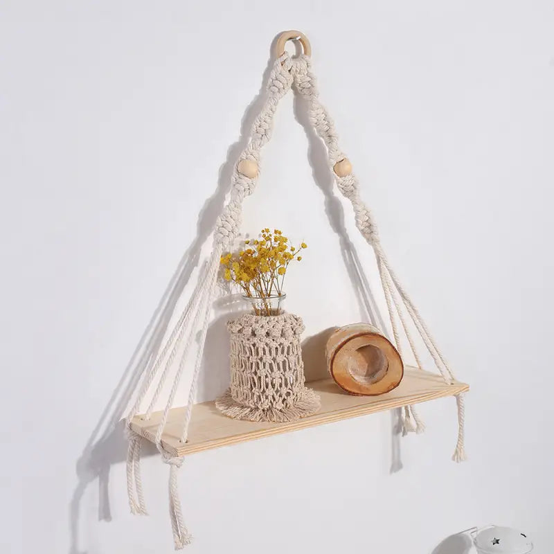 A beautifully handwoven cotton rope wall tapestry plant holder in beige, showcasing intricate knots and designed to hold plants.