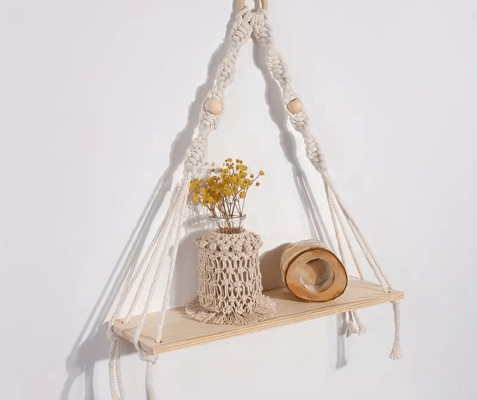 A beautifully handwoven cotton rope wall tapestry plant holder in beige, showcasing intricate knots and designed to hold plants.