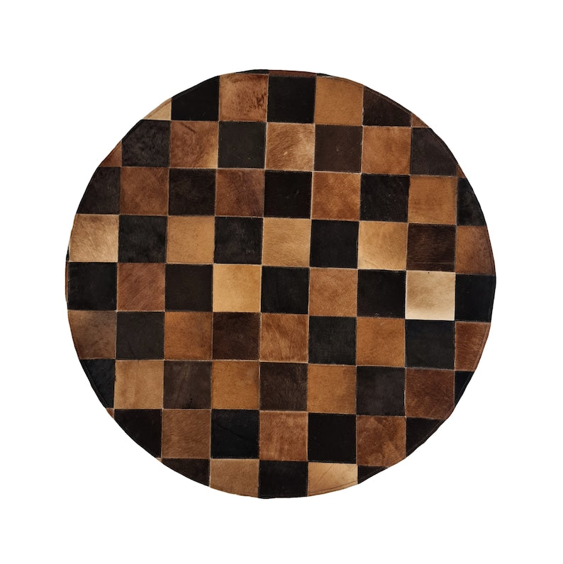 A luxurious round patchwork cow skin rug, showcasing unique leather patterns and textures, perfect for modern home decor.