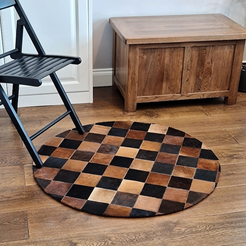 A luxurious round patchwork cow skin rug, showcasing unique leather patterns and textures, perfect for modern home decor.