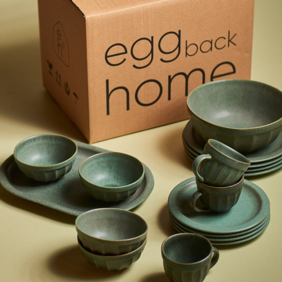 A handmade stoneware bowl with a beautiful green matte glaze, showcasing unique imperfections and a stylish design.