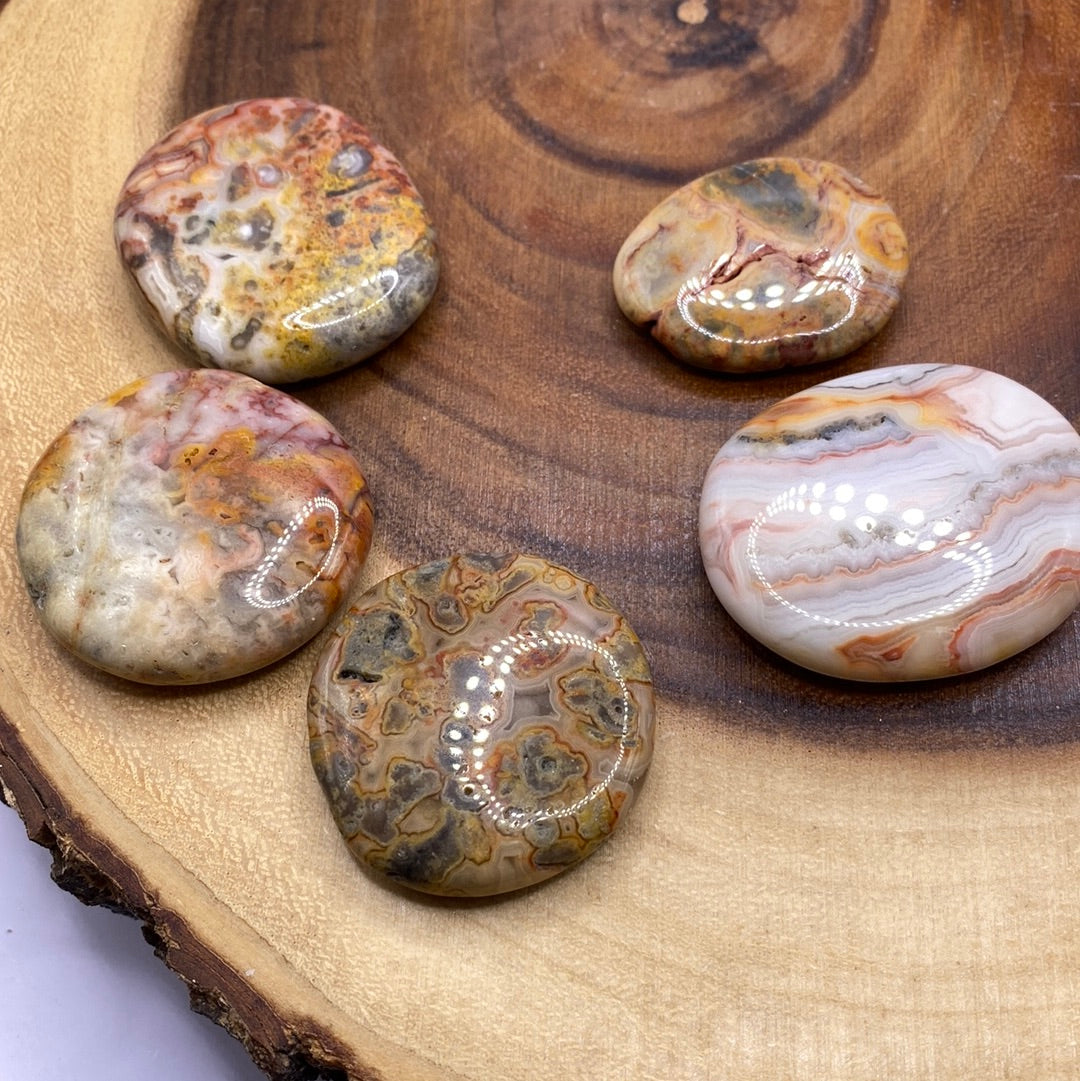 A beautiful Crazy Lace Agate Palm Stone showcasing creamy oranges, browns, and whites with a smooth surface, perfect for meditation.