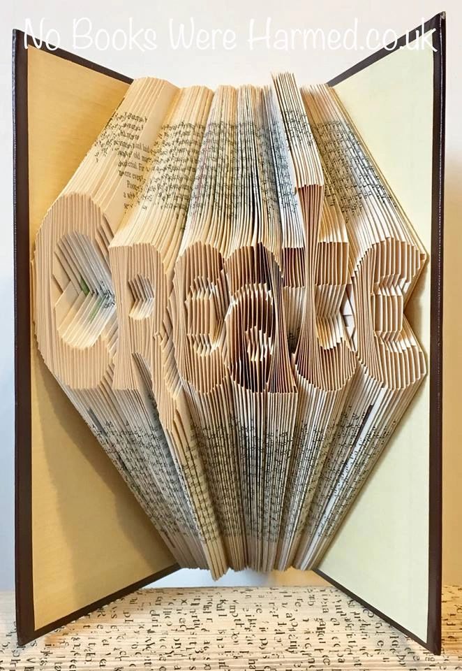 A collection of unique hand-folded book art pieces made from vintage books, showcasing intricate designs and various colors.