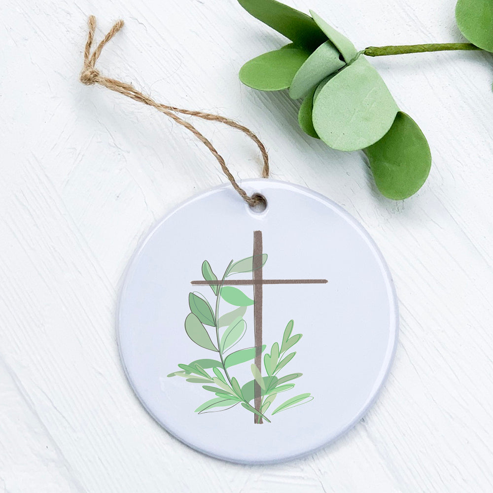 A beautifully crafted porcelain ornament featuring a cross design with leaves, showcasing a glossy finish and vibrant colors.