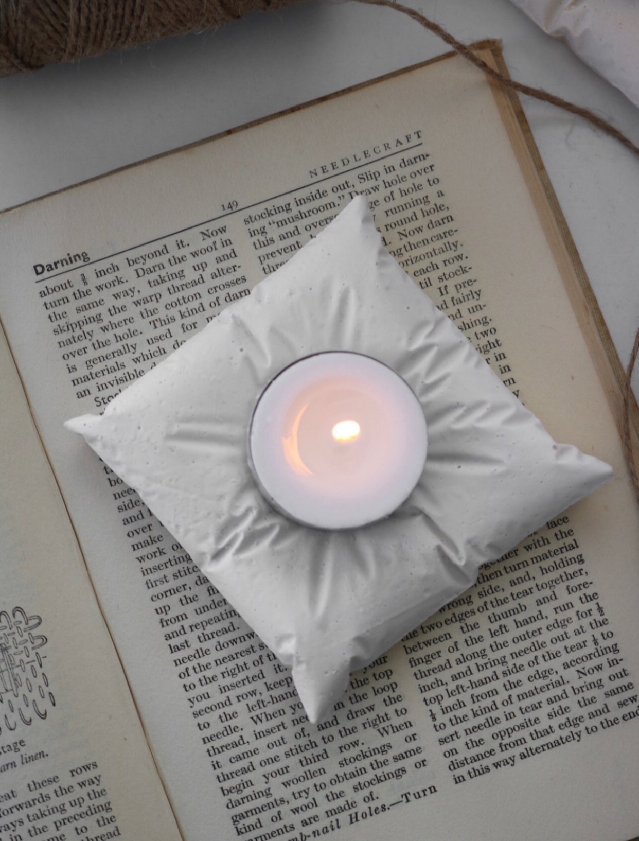 A hand-made cushion tea light holder made from jesmonite, featuring a unique finish and designed to hold tea light candles.