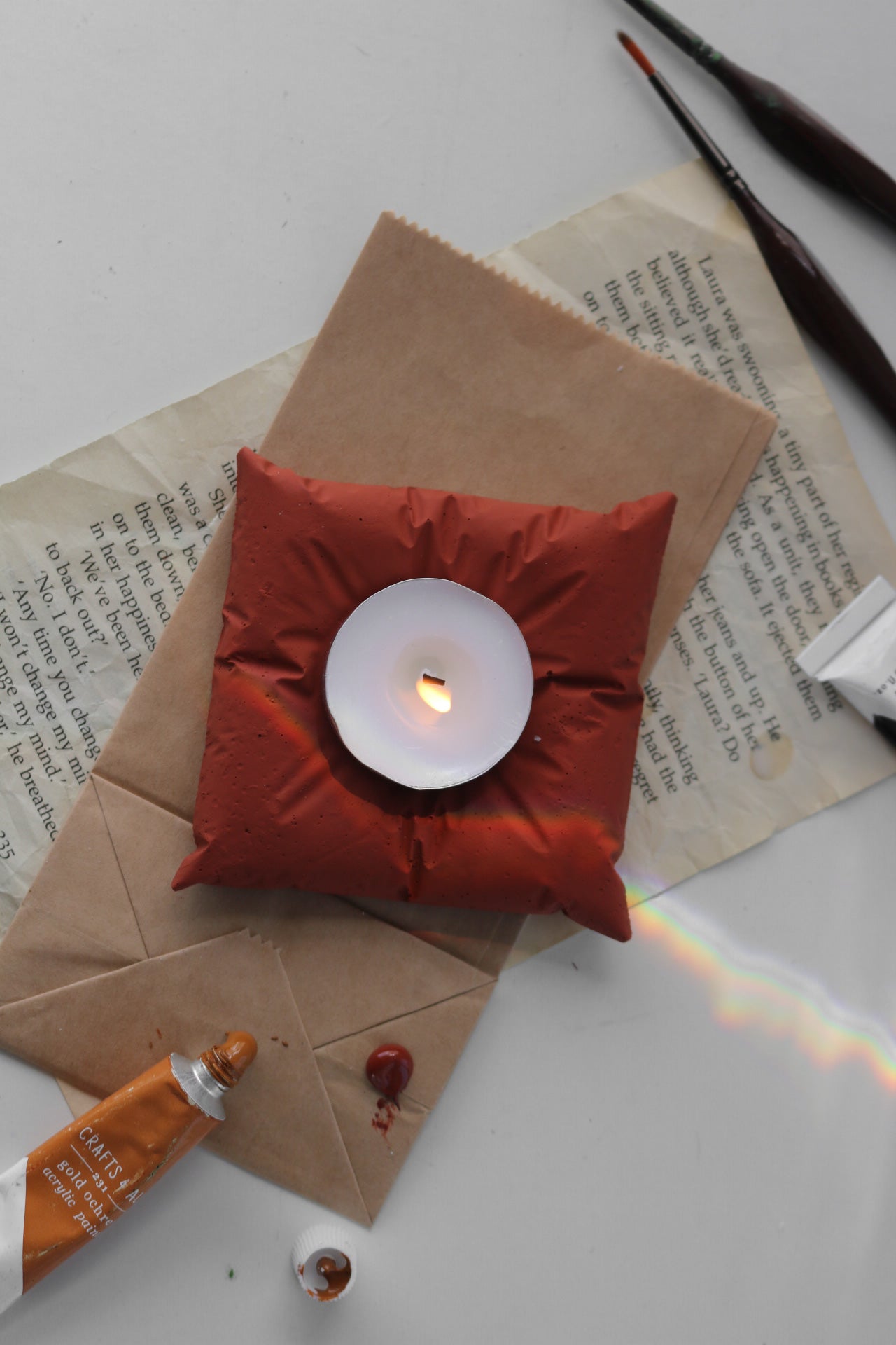 A hand-made cushion tea light holder made from jesmonite, featuring a unique finish and designed to hold tea light candles.