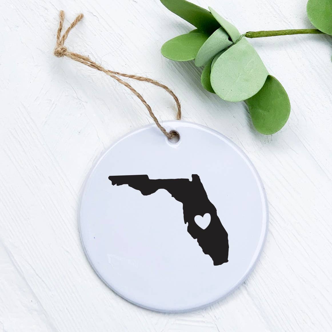 Customizable porcelain ornament featuring a heart and state design, perfect for gifts and home decor.