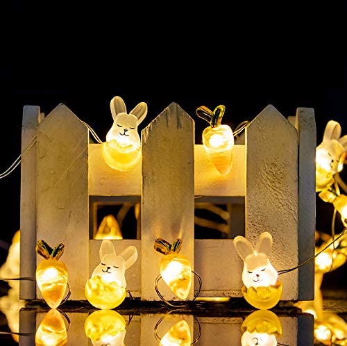 A string of cute Easter lights featuring bunnies and carrots, glowing warmly in a festive outdoor setting.