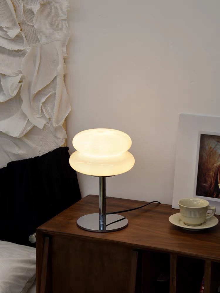 A cute chubby fluffy bedside lamp shaped like a cloud, emitting a warm glow, perfect for creating a cozy atmosphere.